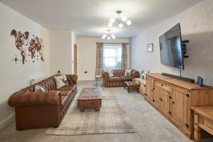 a living room with couches and a flat screen tv at Host & Stay - No 5 Hoggarths Yard in Whitby