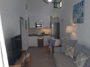 a living room with a couch and a kitchen at Tartanas 144 playa del inglés, jumbo in Playa del Ingles