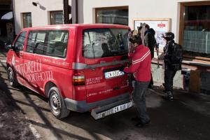 a man is standing next to a red van at Sertorelli Sporthotel in Breuil-Cervinia