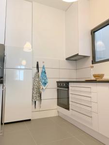 アテネにある2BD New Modern Apartment - Athens Seasideのキッチン(白いキャビネット、冷蔵庫付)