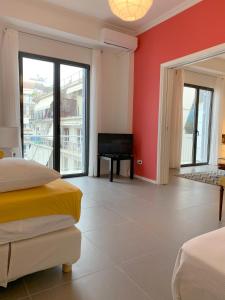 アテネにある2BD New Modern Apartment - Athens Seasideの赤い壁のベッドルーム1室、ベッド1台、バルコニーが備わります。