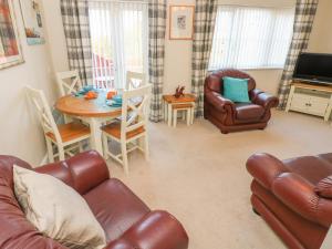 a living room with a couch and a table and chairs at Ffau'r Ddraig in Llanelli