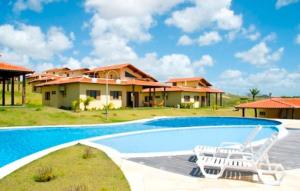ein Bild einer Villa mit einem Pool in der Unterkunft Chalé condomínio beira mar em Zumbi Beach Resort in Rio do Fogo