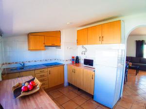 una cocina con armarios de madera y un bol de fruta en una mesa en Vilamagna Apartment 501 en Albufeira