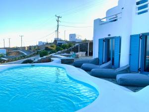 a swimming pool in front of a white house at Psarou Summer Villas in Psarou