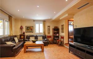 a living room with leather couches and a tv at Cozy Home In Orihuela With Outdoor Swimming Pool in Orihuela
