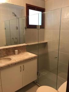 ein Bad mit einer Dusche, einem Waschbecken und einem WC in der Unterkunft Chalé condomínio beira mar em Zumbi Beach Resort in Rio do Fogo