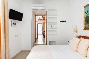 ein Schlafzimmer mit einem Bett und einem TV an der Wand in der Unterkunft VILLA SCHULER GARDEN SUITE TAORMINA IN SELF CATERING in Taormina