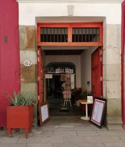 una entrada a un edificio con una puerta roja en La Catrina de Alcala en Oaxaca de Juárez