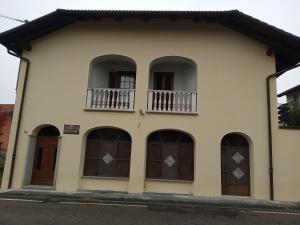 a building with arched windows and a balcony at Bed & breakfast Mezzaluna in Feletto