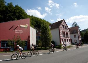 un grupo de personas montando bicicletas por una calle en Behringers Freizeit - und Tagungshotel, en Gössweinstein