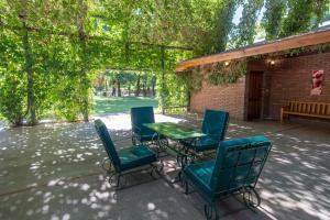 un patio con sillas, una mesa y un banco en Lujan De Cuyo B&B en Luján de Cuyo