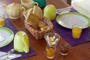 a table with a basket of bread and glasses of orange juice at Chacra del Agua Reserva Privada in Saltos del Moconá