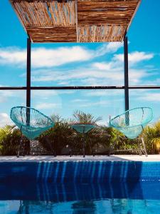 two blue chairs sitting next to a swimming pool at Meliora by Bunik in Playa del Carmen