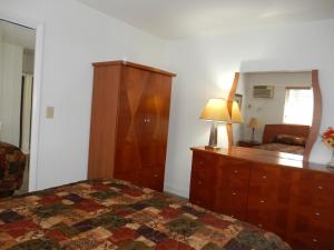 a bedroom with a bed and a dresser and a mirror at Shell Motel Hollywood in Hollywood