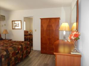 um quarto de hotel com uma cama e uma mesa com um vaso de flores em Shell Motel Hollywood em Hollywood