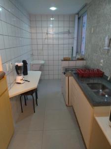 una pequeña cocina con fregadero y mesa en Apart Hotel Quartier Latin, en Vitória