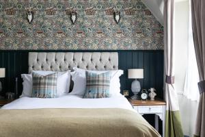 a bedroom with a bed with a green wall at The Fleece at Cirencester in Cirencester