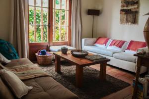 a living room filled with furniture and a window at El Arbol Hostel in La Serena