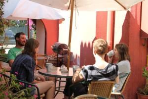 people sitting at a table with umbrellas at El Arbol Hostel in La Serena