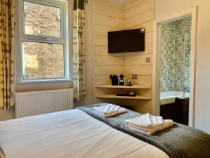 een slaapkamer met een bed en een tv aan de muur bij Vikings Accommodation in York
