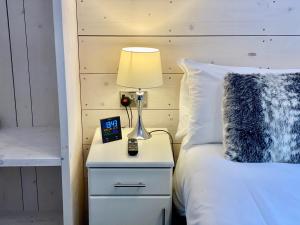 a bed with a lamp and a clock on a night stand at Vikings Accommodation in York