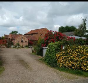 a house with a bunch of flowers next to a driveway at Wolds View in Cornisholme
