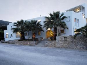 a white house with palm trees in front of it at Filoxenia Apartments in Agia Pelagia Kythira