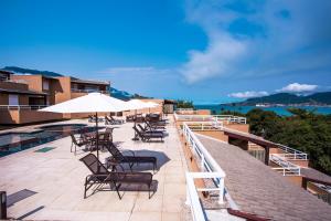 a patio with chairs and umbrellas on a building at Ilhabela Beach Residences in Ilhabela