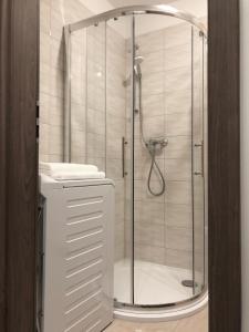 La salle de bains est pourvue d'une douche avec une porte en verre. dans l'établissement Exclusive Home - D. apartman, à Pécs
