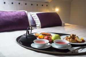 a tray of food with two cups of tea on a bed at Apartments and Rooms Lejletul in Dubrovnik
