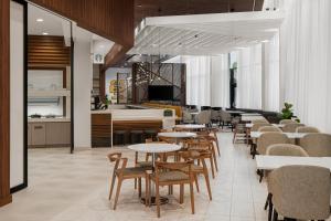 un restaurante con mesas, sillas y un piano en Hyatt Place Atlanta/Perimeter Center en Atlanta