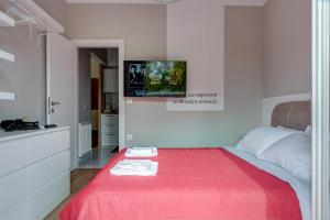 een slaapkamer met een rood bed en een tv aan de muur bij modern style home near the train station in Thessaloniki