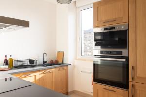 a kitchen with a stove and a window at Cœur de ville, tout équipé, local vélos in Angers