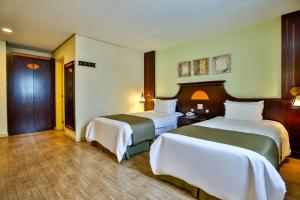 una habitación de hotel con 2 camas en una habitación en Transamerica Prime Batel Curitiba, en Curitiba