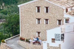 a group of people sitting at a table outside of a building at Cases Noves - Boutique Accommodation - Adults Only in Guadalest