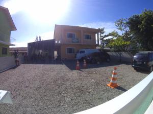 una casa con conos de tráfico naranja delante de ella en Amplo Apartamento na Pinheira en Palhoça