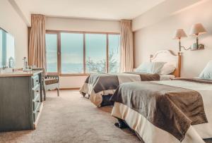 um quarto de hotel com duas camas e uma janela em Wyndham Garden Ushuaia Hotel del Glaciar em Ushuaia
