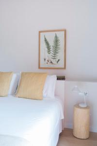 a bedroom with a white bed and a picture on the wall at Hotel Rural Mas de l'Illa in Tivissa