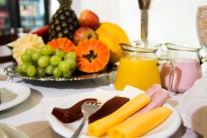 a table topped with a plate of fruit and juice at Hotel Porto Real Aparecida in Aparecida