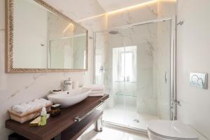 a white bathroom with a sink and a shower at Porta Piccola Luxury Home in Bari