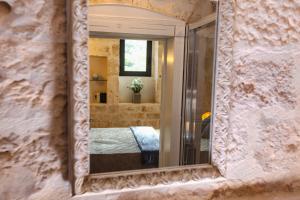 een spiegel in een kamer met een bed erin bij Casina Fumarola in Ostuni