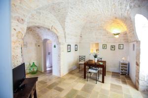 a living room with a table and a tv in a building at Casina Fumarola in Ostuni