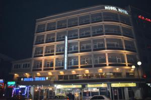 a building with a sign on top of it at night at Nobel Hotel Ankara in Ankara