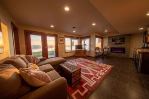 uma sala de estar com um sofá e uma televisão em 180º Puget Sound View em Fox Island