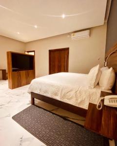 a bedroom with a bed with a television and a phone at Grann Hotel in Ciudad Valles