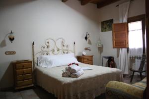 a bedroom with a bed with towels and a dresser at Alojamiento la cañada monfrague in Torrejón el Rubio