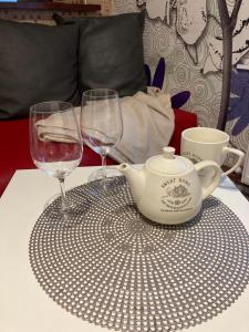uma mesa com dois copos de vinho e um bule de chá em Apartamenti em Cēsis