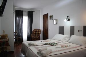 Un dormitorio con una cama con dos libros encima. en Alojamiento y habitacionesla cañada monfrague, en Torrejón el Rubio