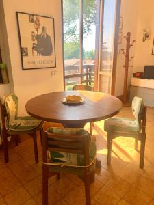 une table et des chaises en bois dans une chambre avec une table dans l'établissement GreenResidence Apartment, à Albavilla